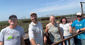 TNC staff smiling together in the bison corrals after a day of work at Kankakee Sands Nature Preserve. 