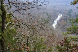 An overlook features a river running throuh a forest in the fall.