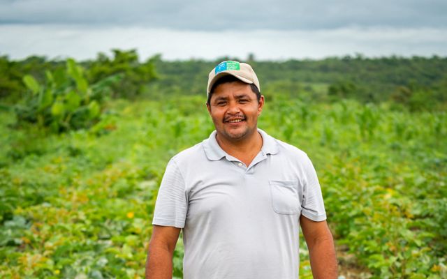 Ermain Requena, regenerative agriculture coordinator at Belize Maya Forest Trust stands among crops.