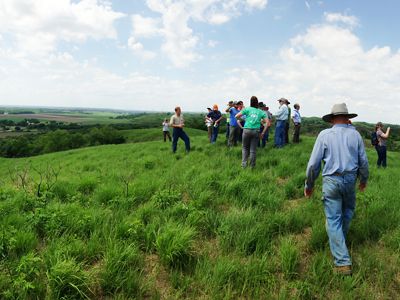 Iowa Board of Trustees hiking up a hill to enjoy the scenic view while visiting Camp Joy Hollow.