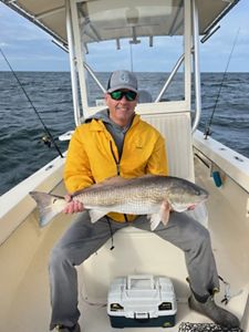 Man on a boat holding a fish.