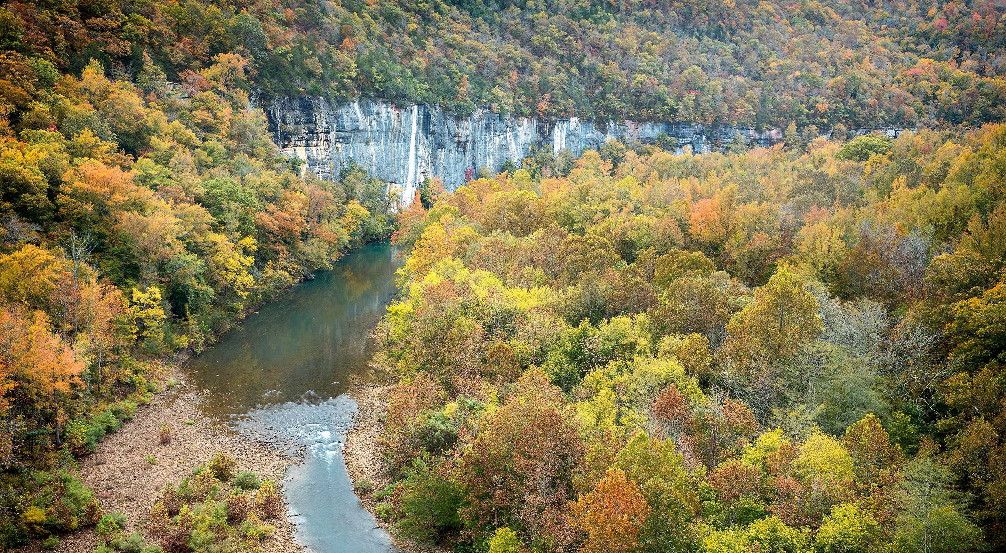 The scenic Buffalo National River flows past towering, rocky bluffs.
