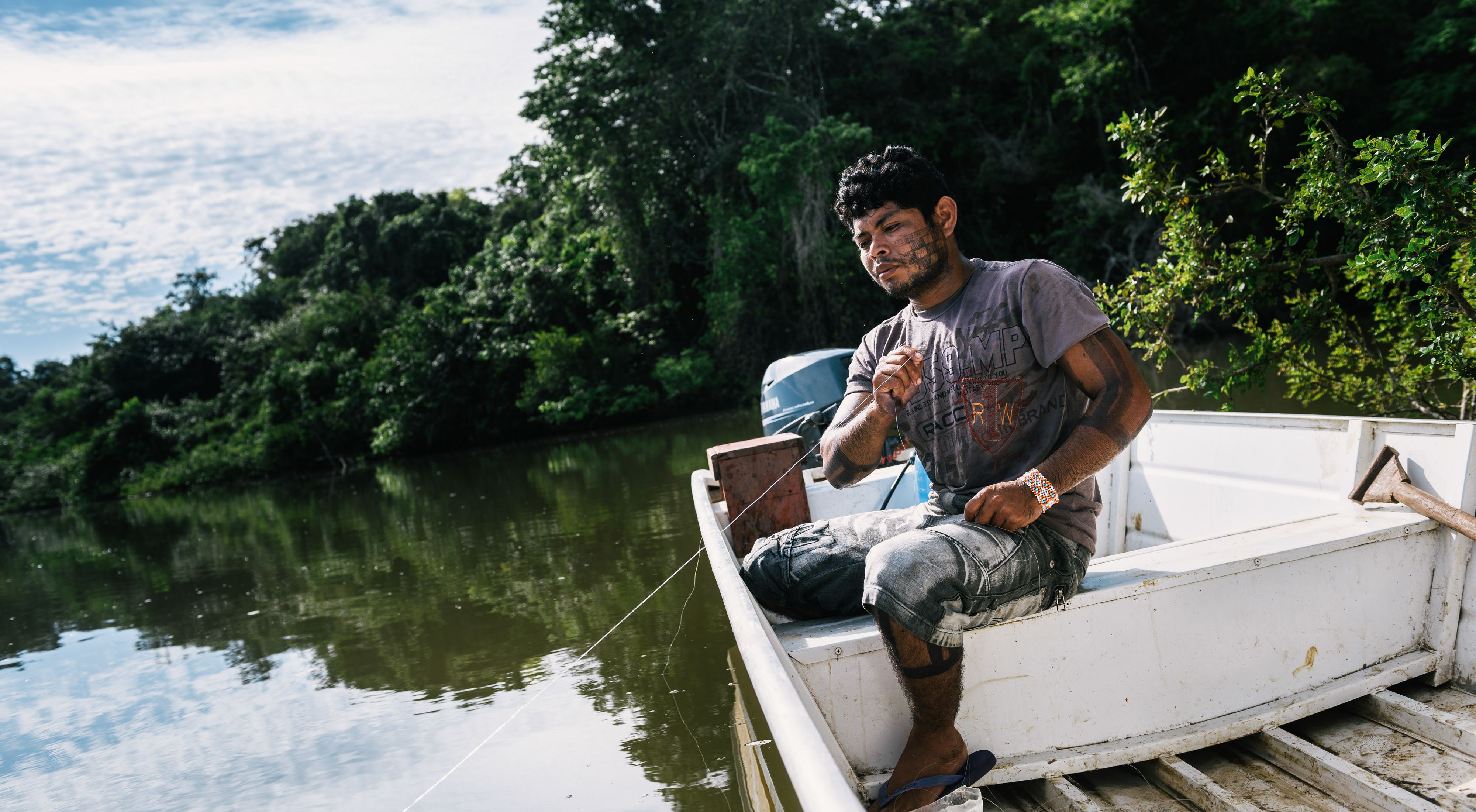 Indígena pescando em barco