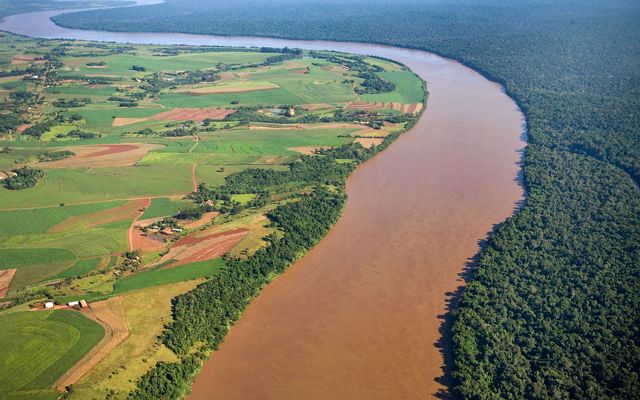 Vista aérea dos campos de cultivo e fazendas a leste da cidade de Foz do Iguaçu e à direita é o Parque Nacional do Iguaçu
