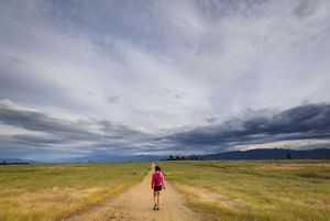 Mulher caminhando na trilha principal em Lower Table Rock, Oregon. 