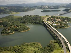 Vista aérea de uma rodovia de várias faixas que atravessa o reservatório de Atibaina, próximo à cidade de Nazaré Paulista, Brasil. O reservatório faz parte do sistema Cantarei