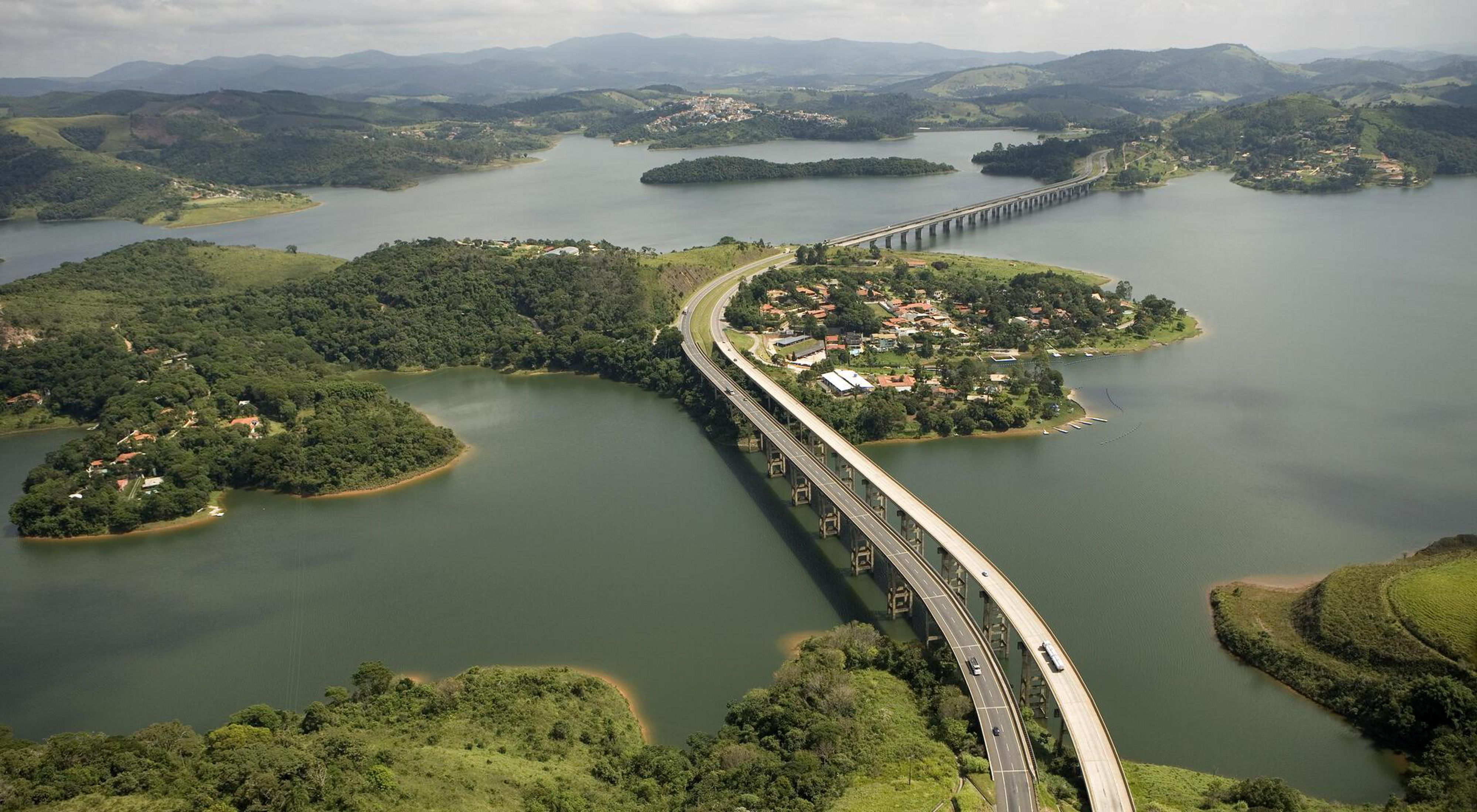 Vista aérea de uma rodovia de várias faixas que atravessa o reservatório de Atibaina, próximo à cidade de Nazaré Paulista, Brasil. O reservatório faz parte do sistema Cantareira (o maior sistema de ab