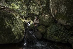 Proprietário rural olhando para o céu próximo a córrego.