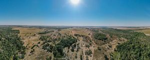 Vista aérea de propriedade rural no Cerrado durante a seca, com pastagens e fragmentos de vegetação nativa.