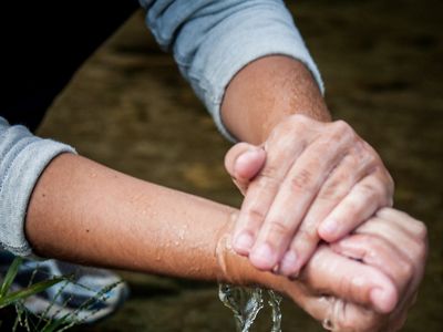 Um de nossos parceiros do projeto "Produtor de Águas" da The Nature Cconservancy Brasil lavando suas mãos em uma nascente em Rio Claro, Rio de Janeiro.