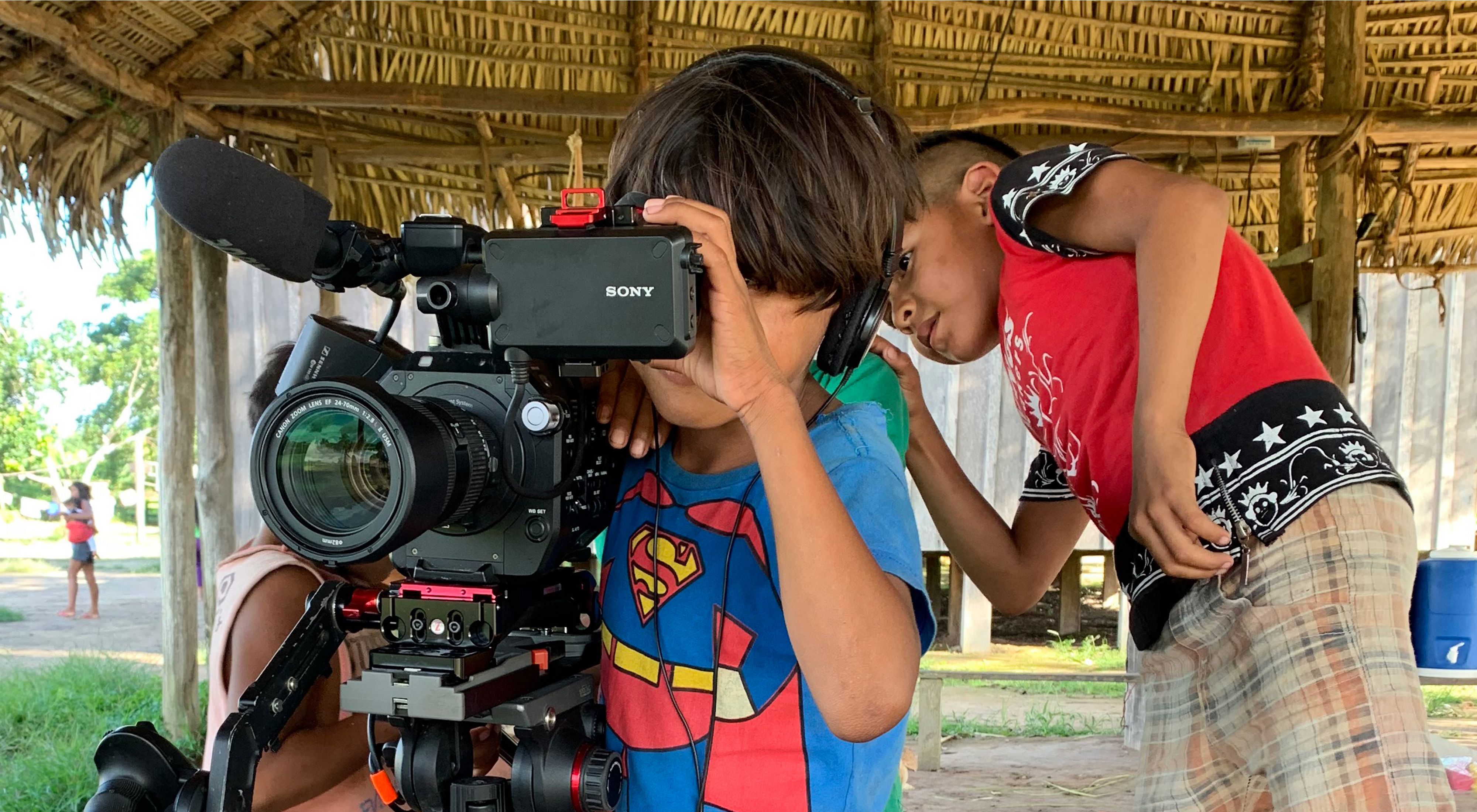 Crianças indígenas do povo Parakanã brincando com a câmera durante as filmagens de uma série sobre artesanato do povo Parakanã.