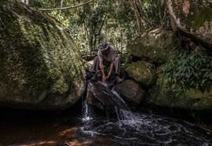 Agricultor lavando as mãos em corrego em sua propriedade