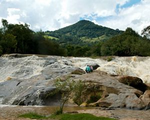 Dois pesquisadores examinam água em rio.