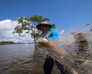 Fisherman throws net in Tapajós River