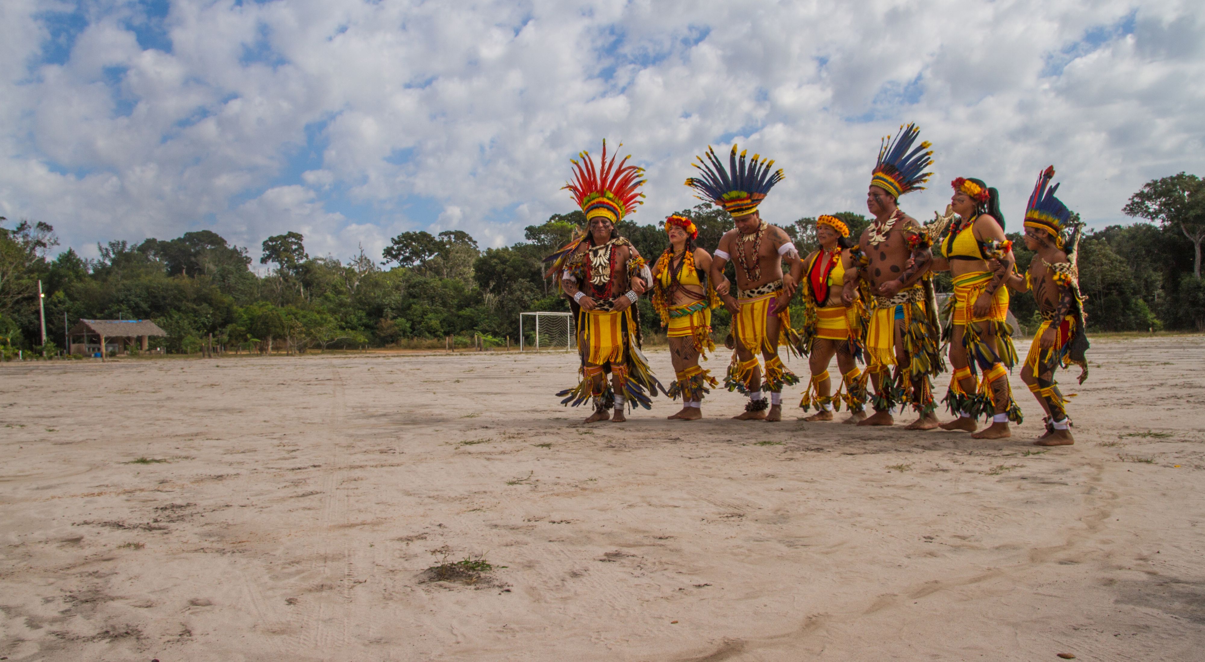 Indígenas Paresi dançando em espaço aberto na aldeia.