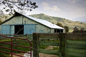 A barn and cattle fence in front of the mountains in the heart of the Tehachapi corridor, California.