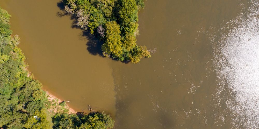 The Cahaba River unites and waters mix in a brown river.