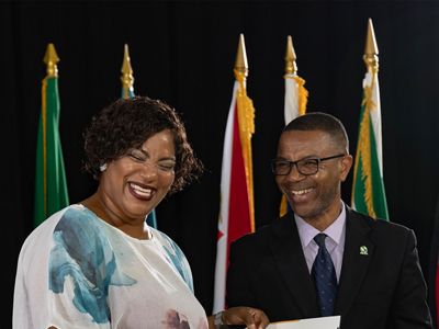 Two people stand at a podium during an award ceremony.