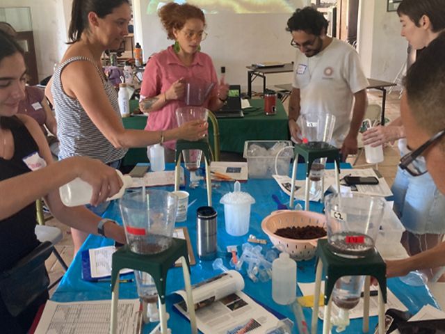 Participants work around a table in a workshop on coral fertilization and propagation.