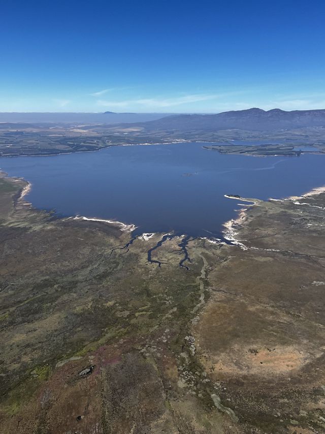 Aerial shot of a small, blue body of water.