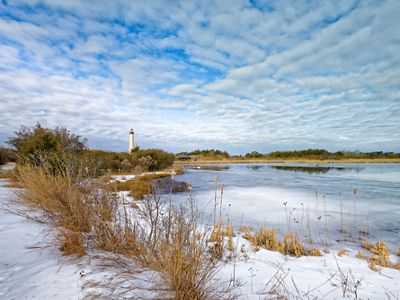 Snow-covered beach and view of the lighthouse.