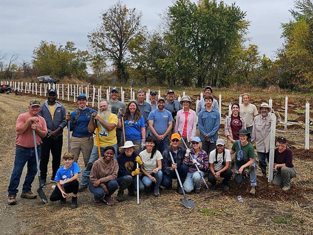 a group of people with shovels posing for a photo.