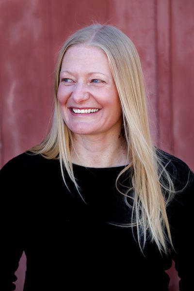 A woman smiles for a headshot, looking to the side.