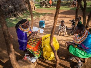 Two Samburu women sitting and looking at a book