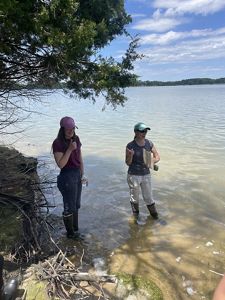 Two staff members standing over a marsh.