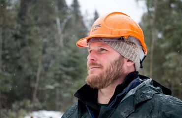 Conservation forester Chris Stone wears an orange hard hat.