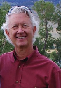 A man with sunglasses on his head smiles.