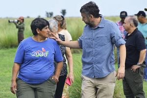 un hombre y una mujer con camisetas azules hablando mientras caminan.