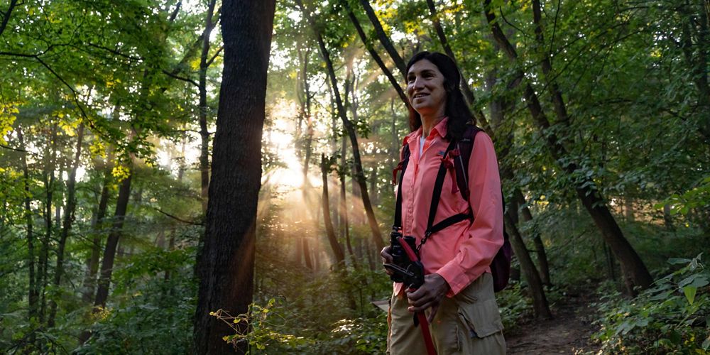 TNC volunteer Cindy Leffler hikes the forest at Green's Bluff nature preserve.