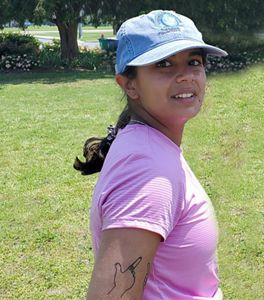 Claudia Moncada headshot. VVCR intern Claudia Moncada stands in an open park in Chincoteague during a community engagement event.