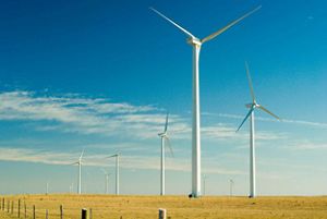 Five large wind turbines standing on grassland plains.