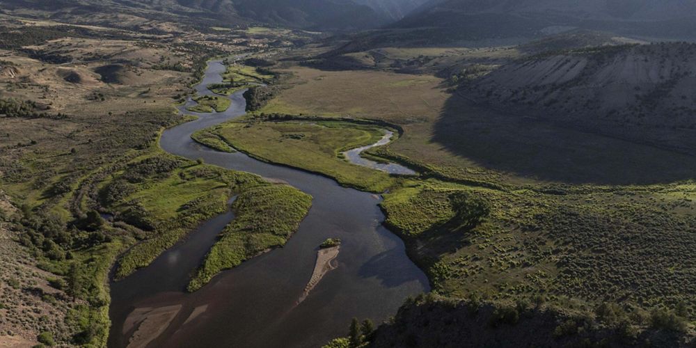 Aerial view of a river winding through a wide river basin.
