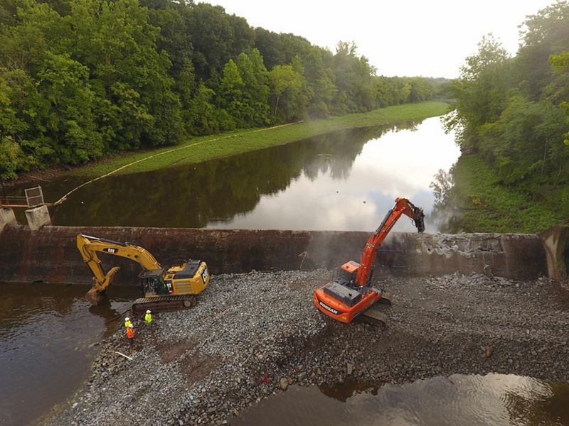 Removal of a dam with machinery in background.