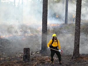 A woman with a yellow shirt is surrounded by smoke.