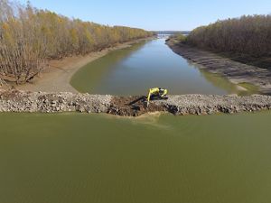 An aerial view of a backhoe cutting a notch in a dike at Coffee Point on the Mississippi River.