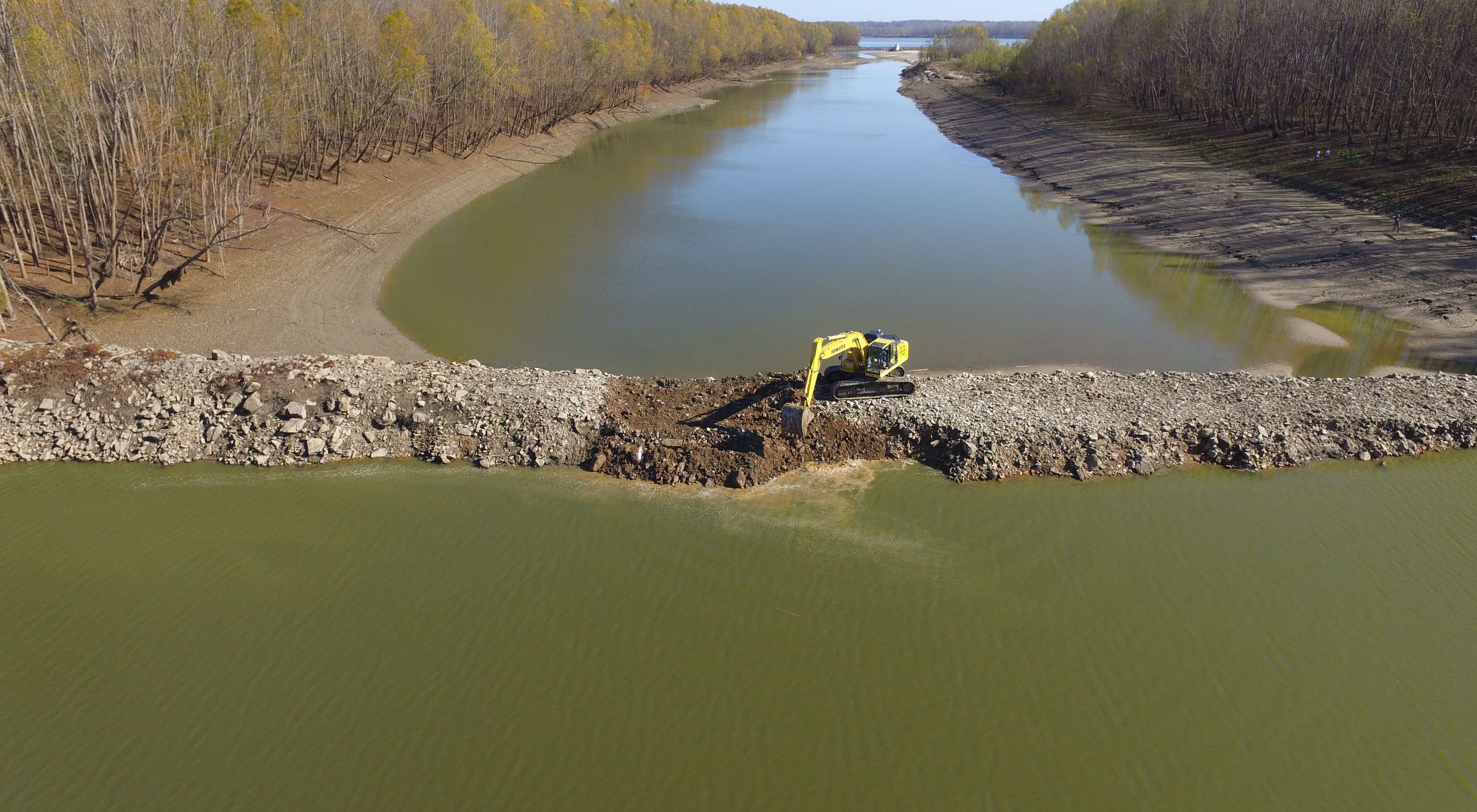 An aerial view of a backhoe cutting a notch into a dike at Coffee Point on the Mississippi River