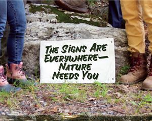 A message about nature is framed by people wearing outdoor gear.