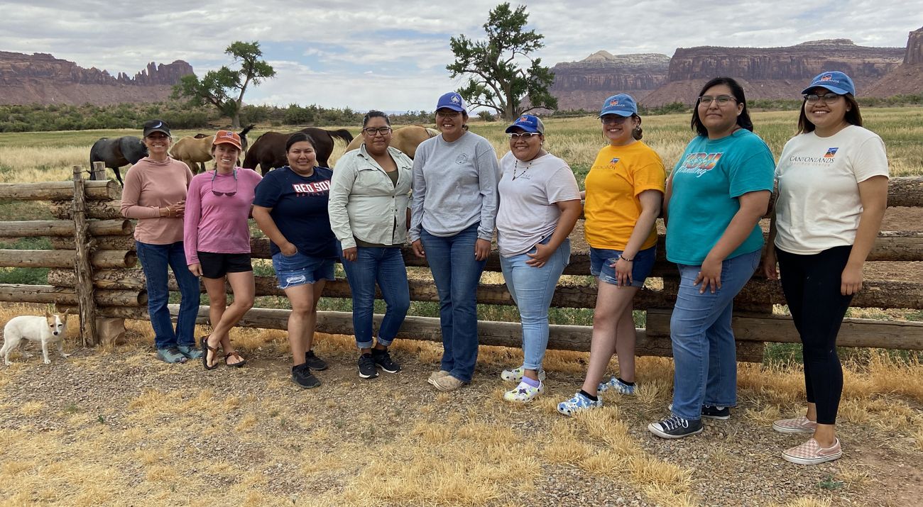 A group of interns standing over a biocrust garden at the Canyonlands Research Center.