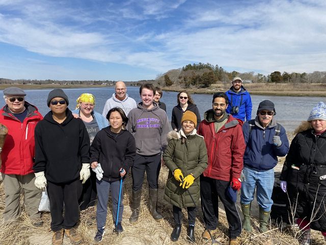 Volunteers standing together for a photo in front of waterway.