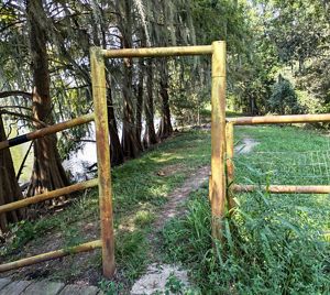 A wooden fence highlights the beginning of a trail.