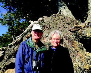 Two hikers posed in front of a tree