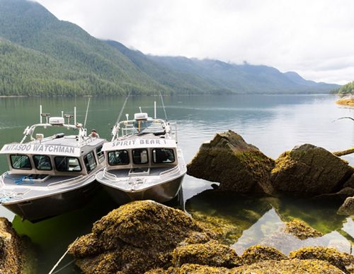 two boats parked near some boulders