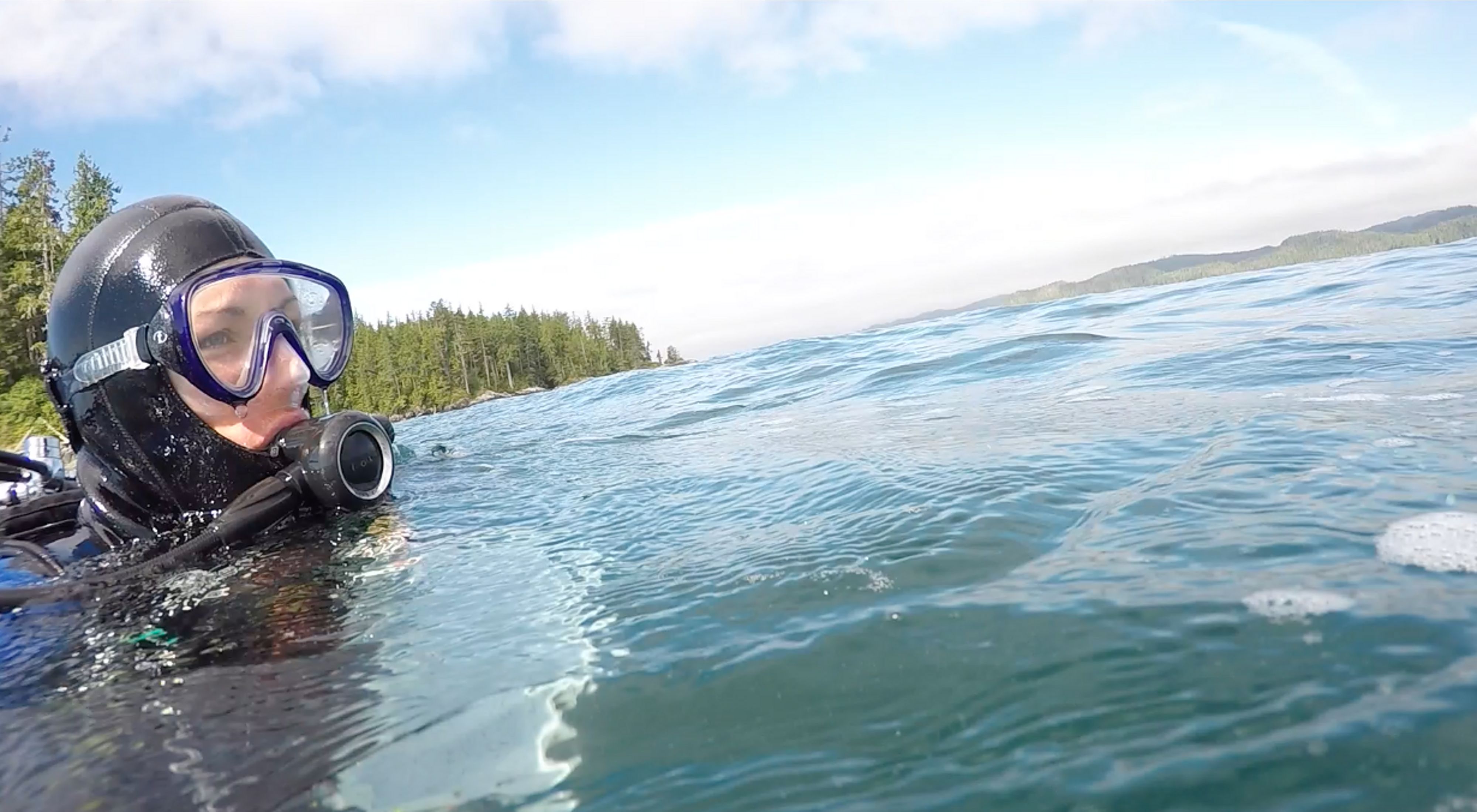 Marine ecologist Jenn Burt in scuba gear at ocean's surface