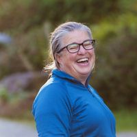a woman in glasses laughing outside