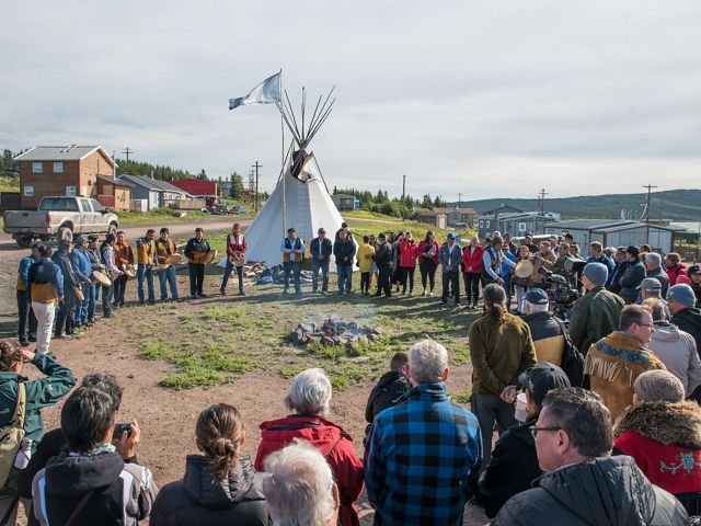 A group stands in a ceremonial circle in Łutsël K’é, Northwest Territories to celebrate Establishment Agreements for Thaidene Nëné.