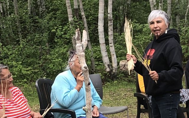 Margo hands out hazel sticks to members of the Misipawistik Cree Nation to share a traditional song from the Yurok tribe.